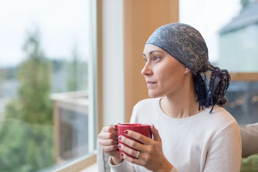 Woman holding coffee cup and looking out window